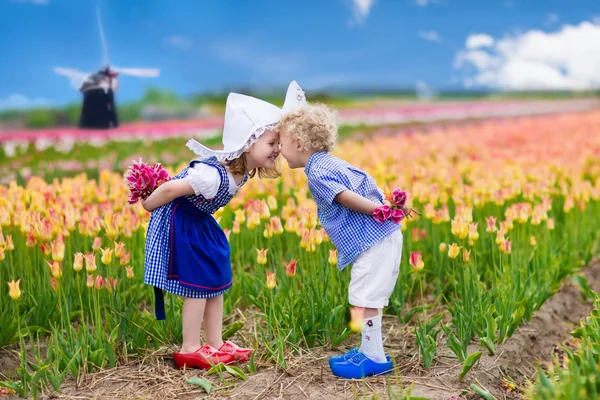 Niños holandeses en el campo de tulipanes — Foto de Stock