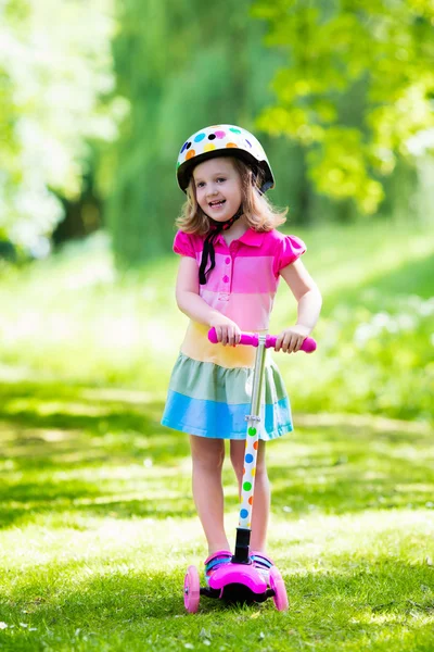 Menina montando uma scooter colorido — Fotografia de Stock