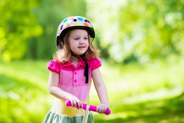 Niña montando un scooter colorido —  Fotos de Stock