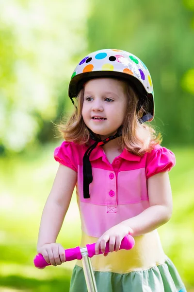 Liten flicka Rider en färgglad skoter — Stockfoto