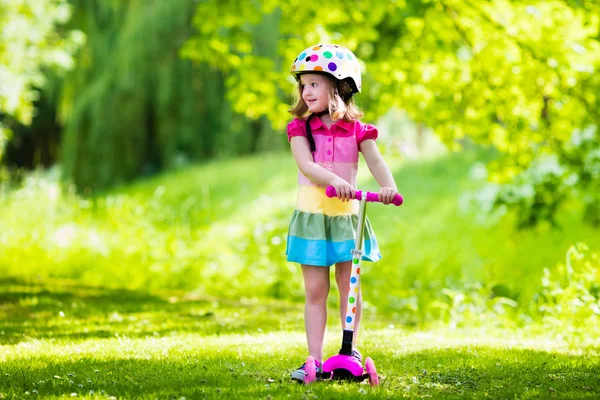 Bambina in sella a uno scooter colorato — Foto Stock