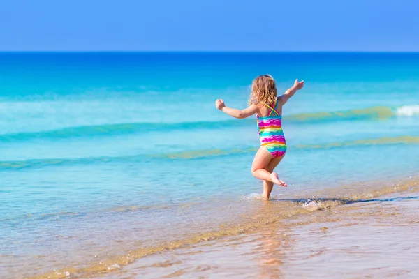 Little girl playing on tropical beach — Stock Photo, Image
