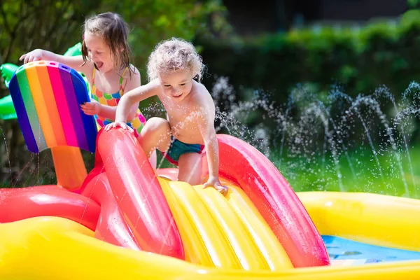 Crianças brincando na piscina inflável — Fotografia de Stock