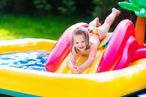 Little girl playing in inflatable garden swimming pool — Stock Photo, Image