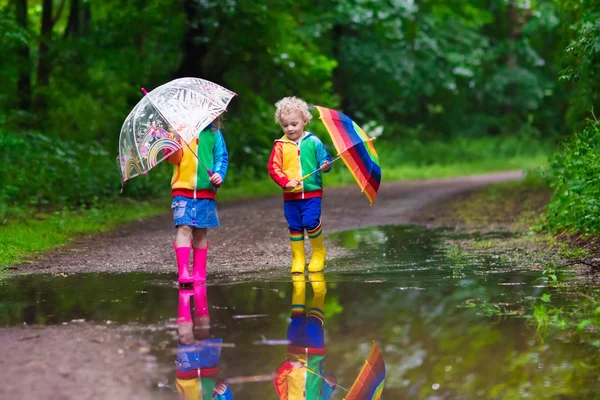 Niños jugando bajo la lluvia — Foto de Stock