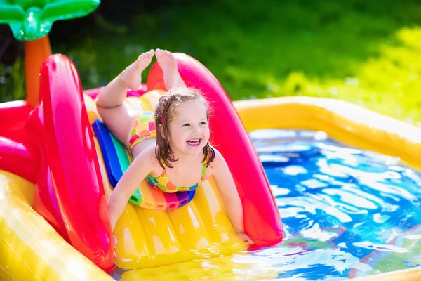 Menina que joga na piscina inflável do jardim — Fotografia de Stock