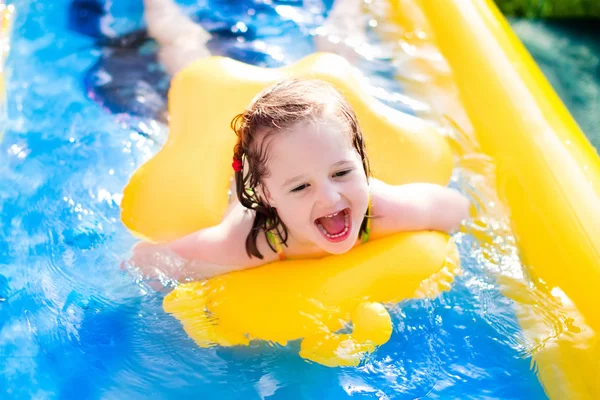 Liten flicka som leker i Uppblåsbara trädgård pool — Stockfoto