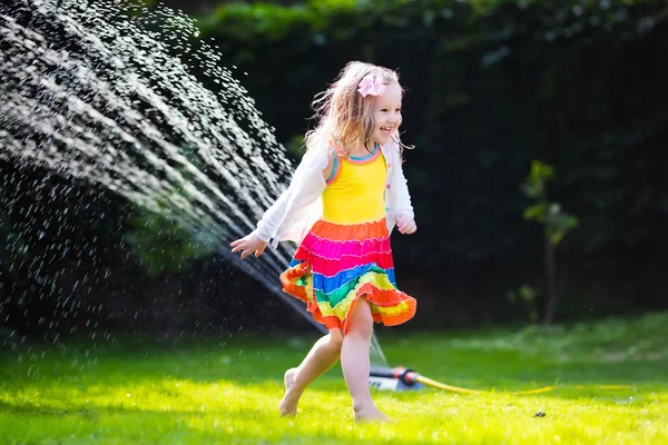 Niños jugando con aspersor de jardín —  Fotos de Stock