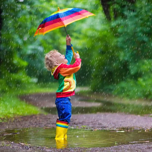 Niño jugando bajo la lluvia — Foto de Stock