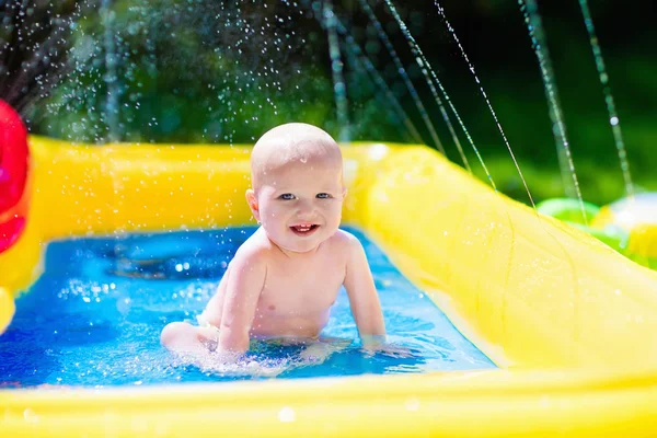 Happy baby playing in swimming pool — Stock Photo, Image