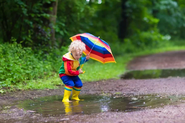 Niño jugando bajo la lluvia — Foto de Stock