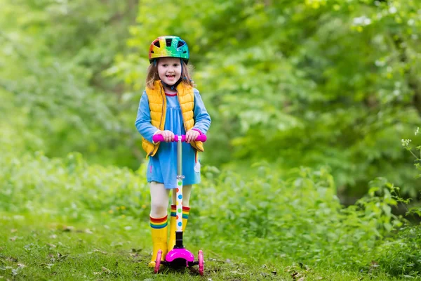 Petite fille chevauchant un scooter coloré — Photo