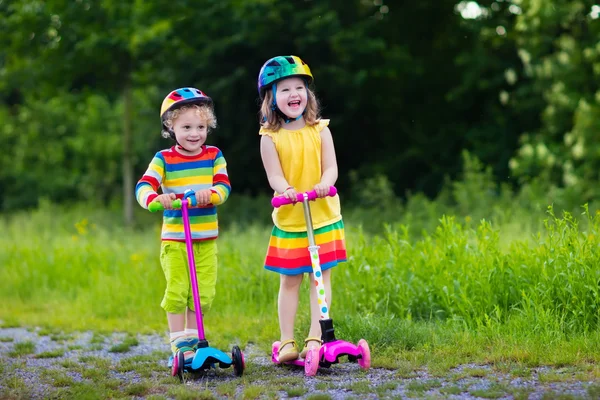 Kinder fahren Roller im Sommerpark — Stockfoto