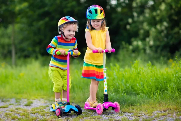 Kinder fahren Roller im Sommerpark — Stockfoto