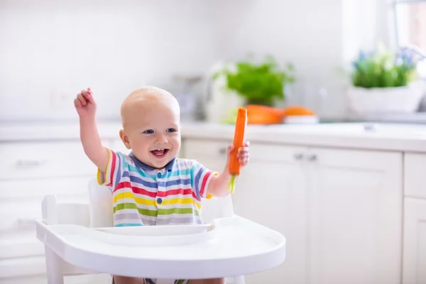 Pequeno bebê comer cenoura — Fotografia de Stock