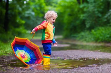 Yağmur altında oynayan çocuk