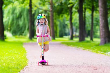 Küçük kız renkli bir scooter sürme