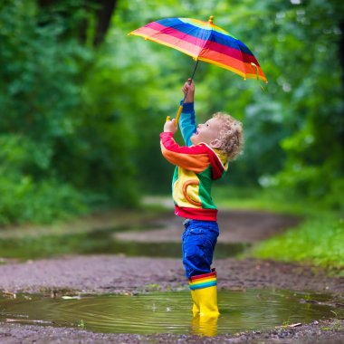 Yağmur altında oynayan çocuk
