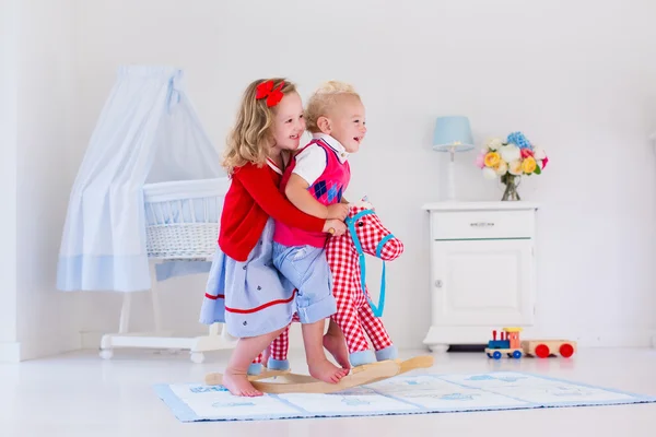 Kids playing with rocking horse — Stok fotoğraf