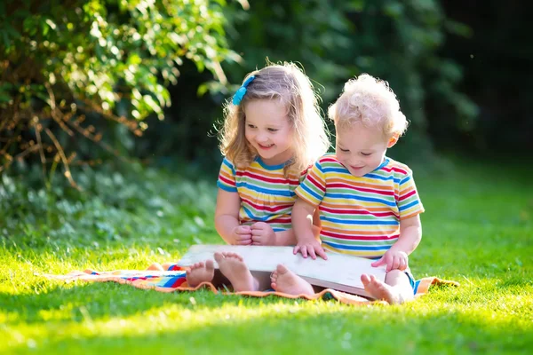 İki çocuk yaz bahçede okuma — Stok fotoğraf
