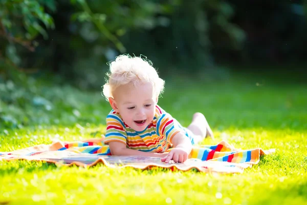 Little boy reading in summer garden — Stock Photo, Image