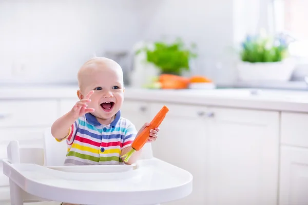 Pequeño bebé comiendo zanahoria — Foto de Stock
