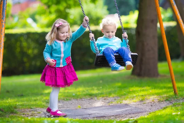 Kids on playground swing — Stock Photo, Image