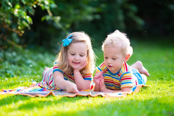 Dwoje dzieci czytania w ogrodzie — Zdjęcie stockowe