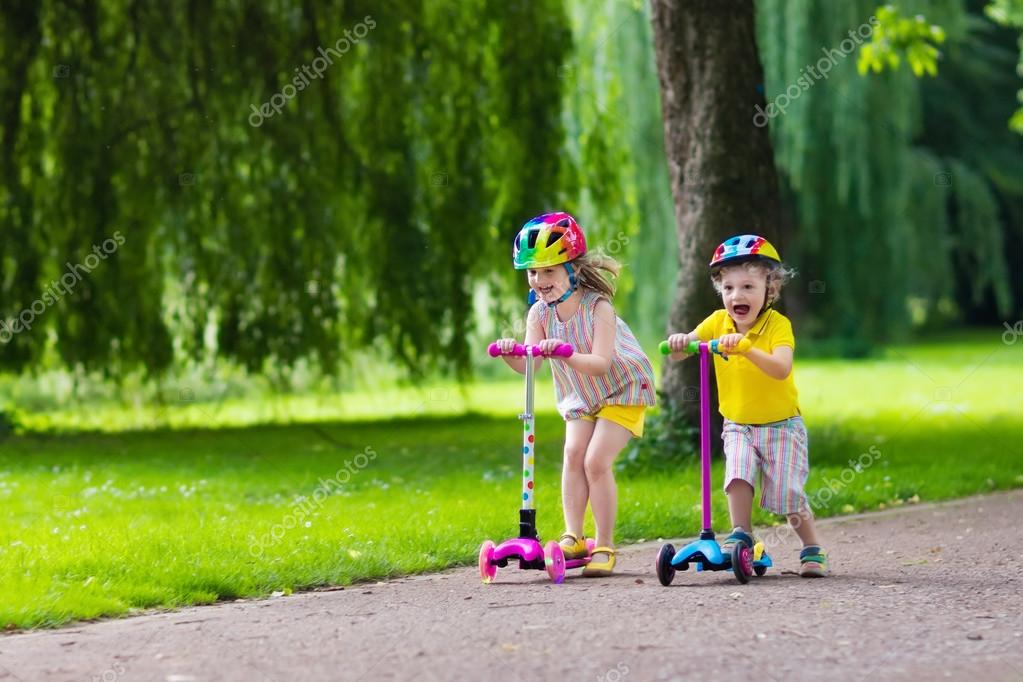 Little kids riding colorful scooters — Stock Photo © FamVeldman 112768882