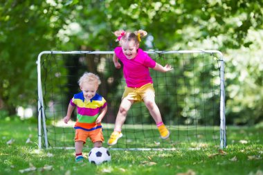 Okul bahçesinde futbol oynayan çocuklar