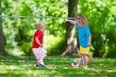 Okul bahçesinde futbol oynayan çocuklar