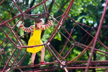 Okul bahçesinde oyun parkında eğlenceli olan çocuğun