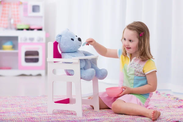 Bambina alimentando il suo orso giocattolo — Foto Stock