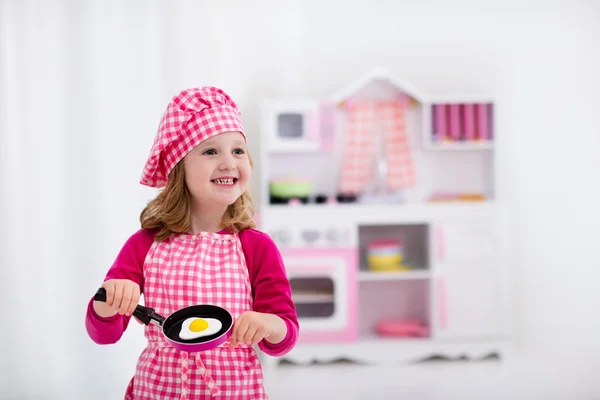 Klein meisje spelen met speelgoed keuken — Stockfoto