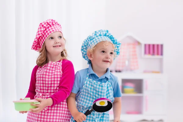 Crianças brincando com cozinha de brinquedo — Fotografia de Stock