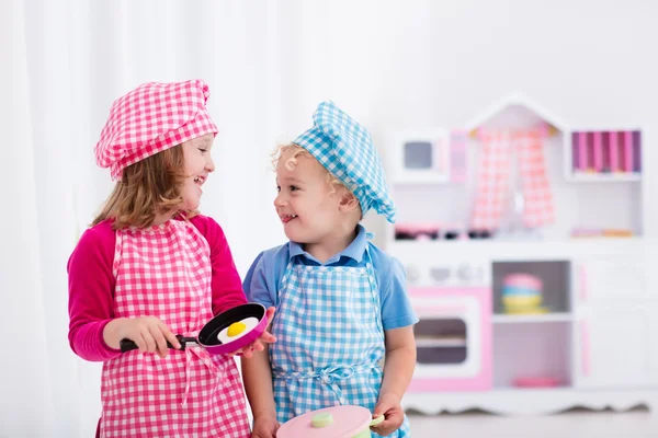 Crianças brincando com cozinha de brinquedo — Fotografia de Stock