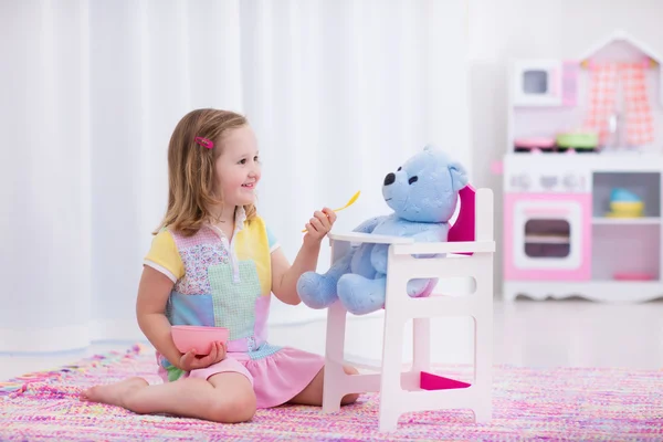 Little girl feeding her toy bear — Stock Photo, Image