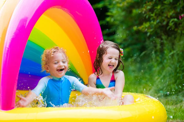 Crianças brincando na piscina inflável — Fotografia de Stock