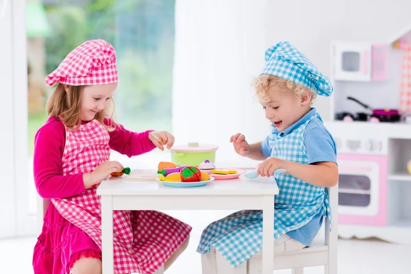 Niños jugando con cocina de juguete —  Fotos de Stock