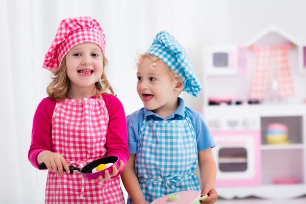 Kids playing with toy kitchen — Stock Photo, Image