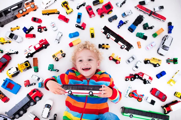 Küçük çocuk oyuncak arabalarla oynuyor. — Stok fotoğraf