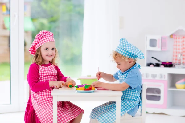 Kids playing with toy kitchen — Stock Photo, Image