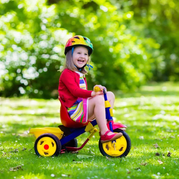 Bambina in sella a un triciclo — Foto Stock