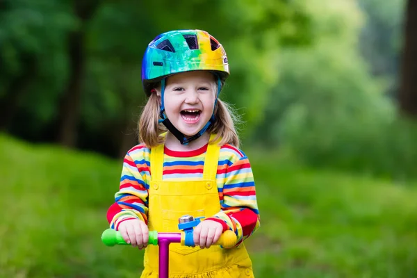 Kleines Mädchen auf einem bunten Motorroller — Stockfoto