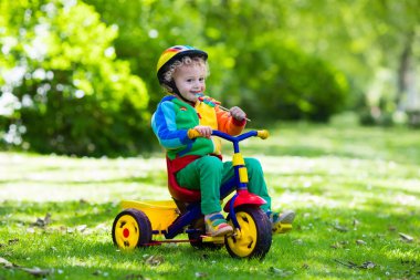 Little boy on colorful tricycle clipart