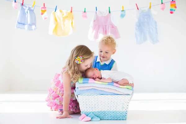 Bratr a sestra líbání novorozeně — Stock fotografie