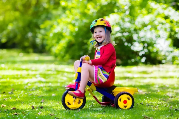 Bambina in sella a un triciclo — Foto Stock