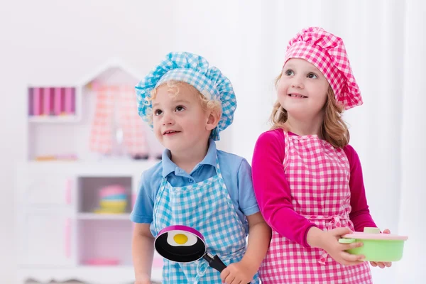 Kids playing with toy kitchen — Stock Photo, Image