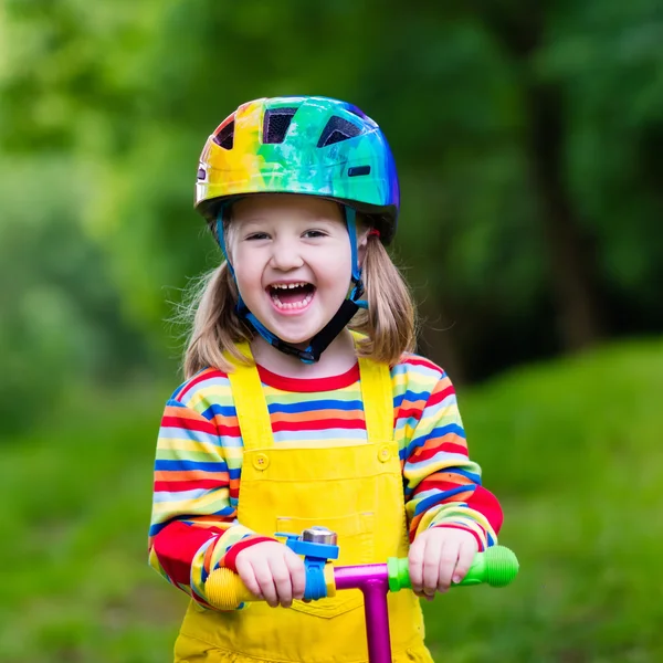 Küçük kız renkli bir scooter sürme — Stok fotoğraf