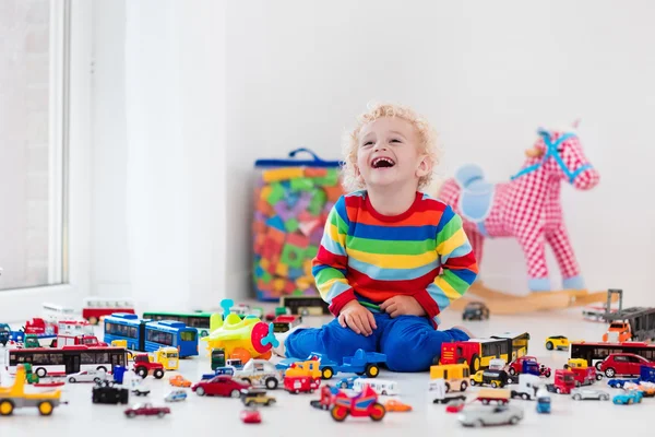 Маленький хлопчик грає з іграшковими машинами — стокове фото